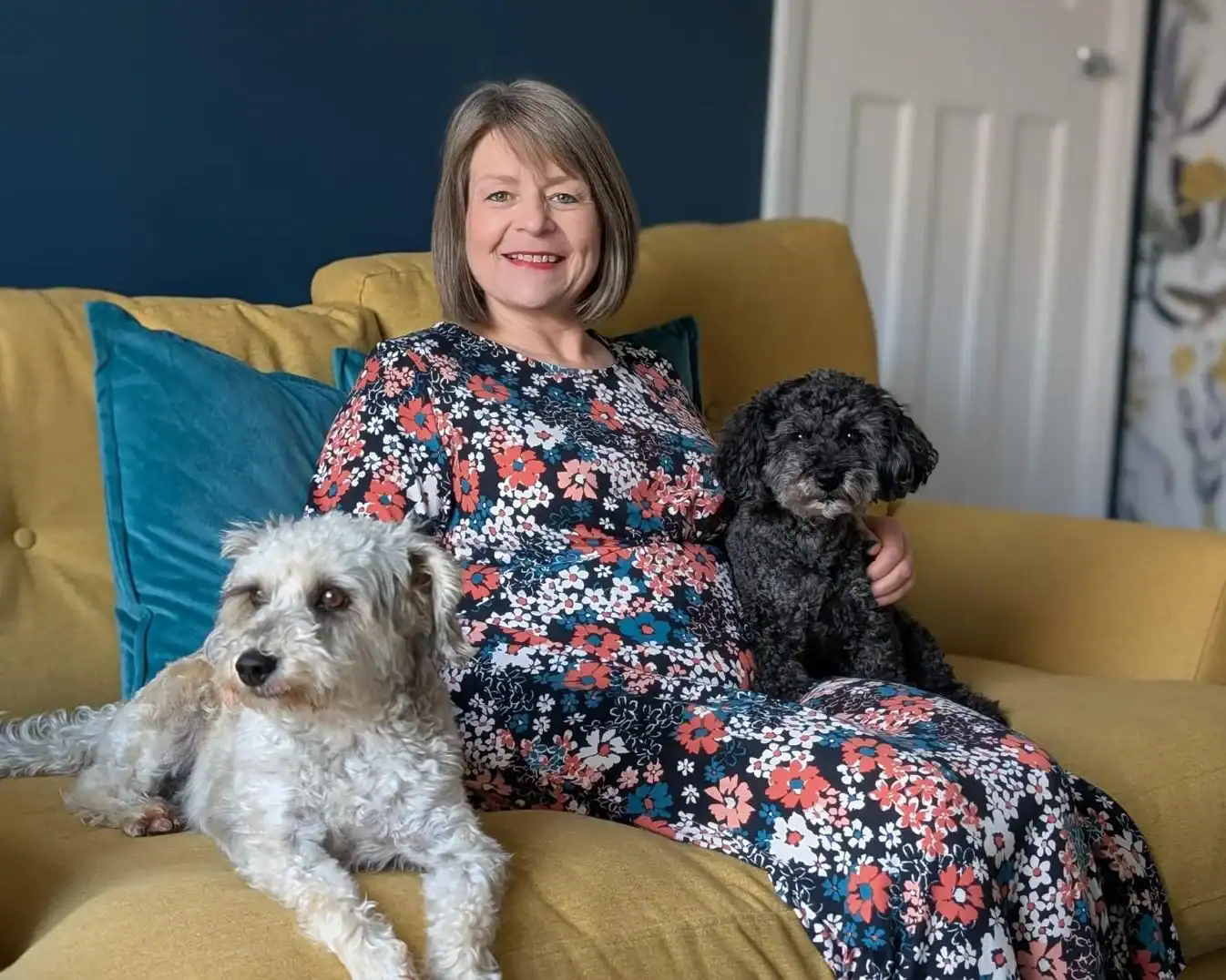 Melinda with two dogs on yellow couch